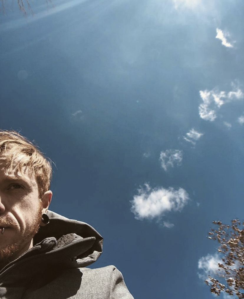 Kade Mitchell in a selfie with half his face and the rest of the image is the blue sky