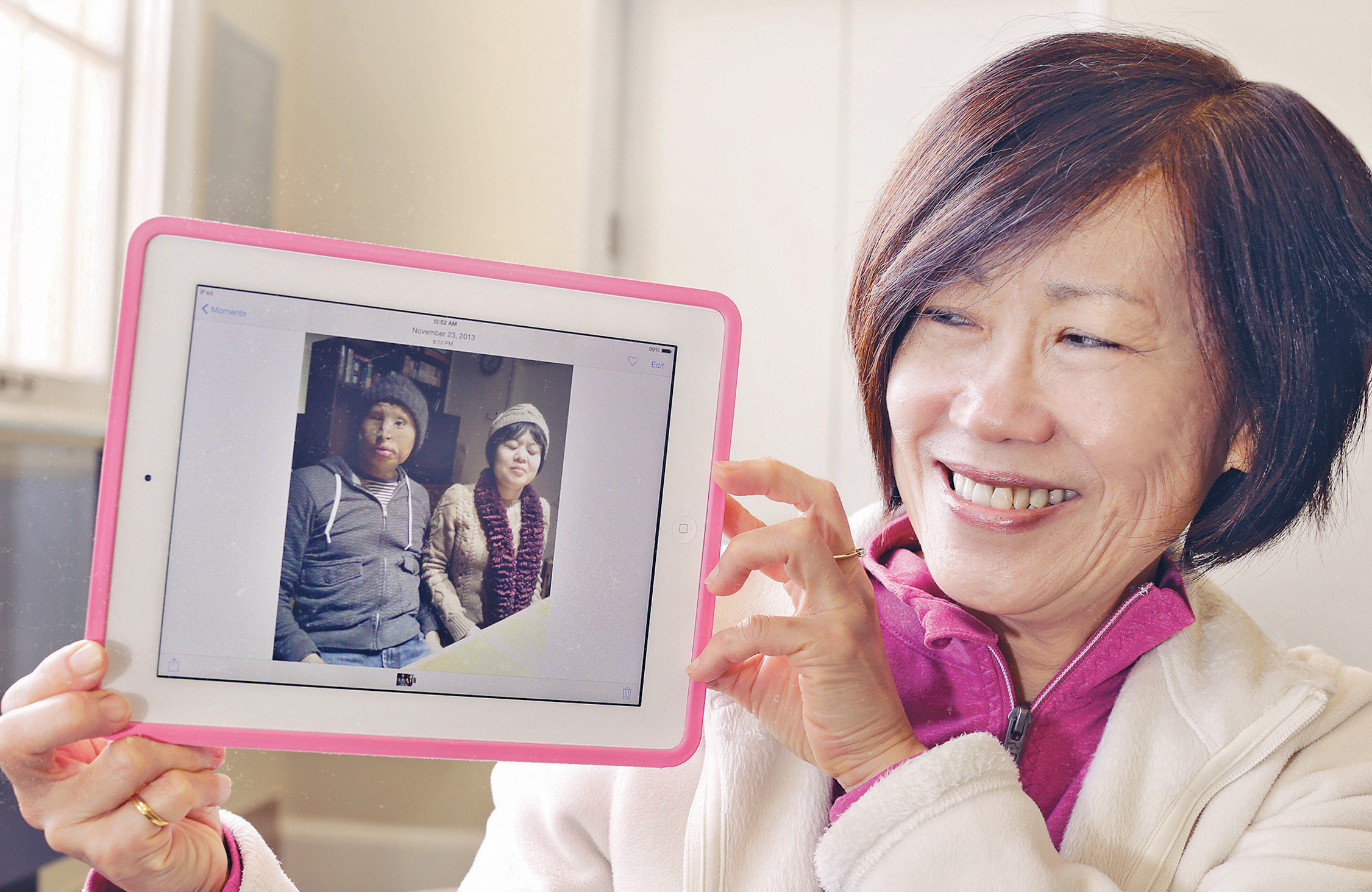 Photo of Sue showing an image of her son and his partner