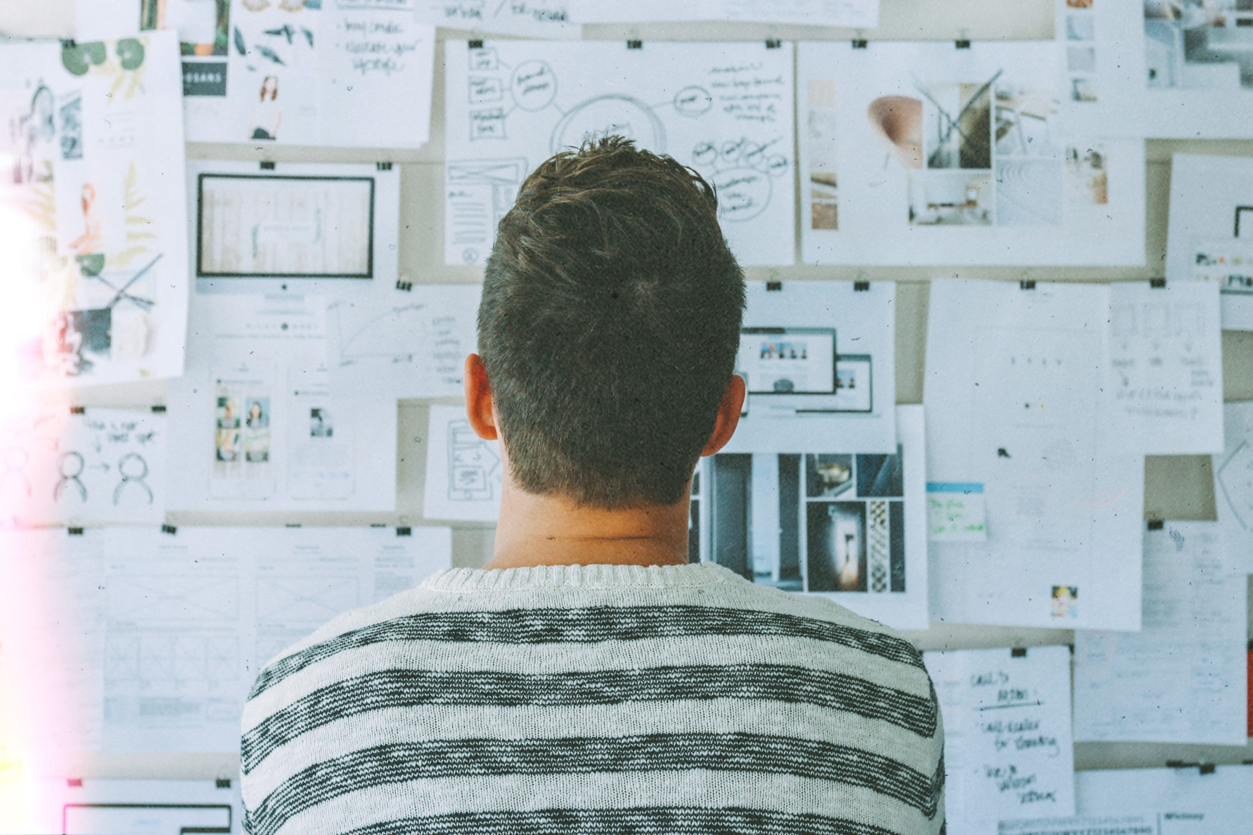 A person looking at a board of papers with goals written on them.